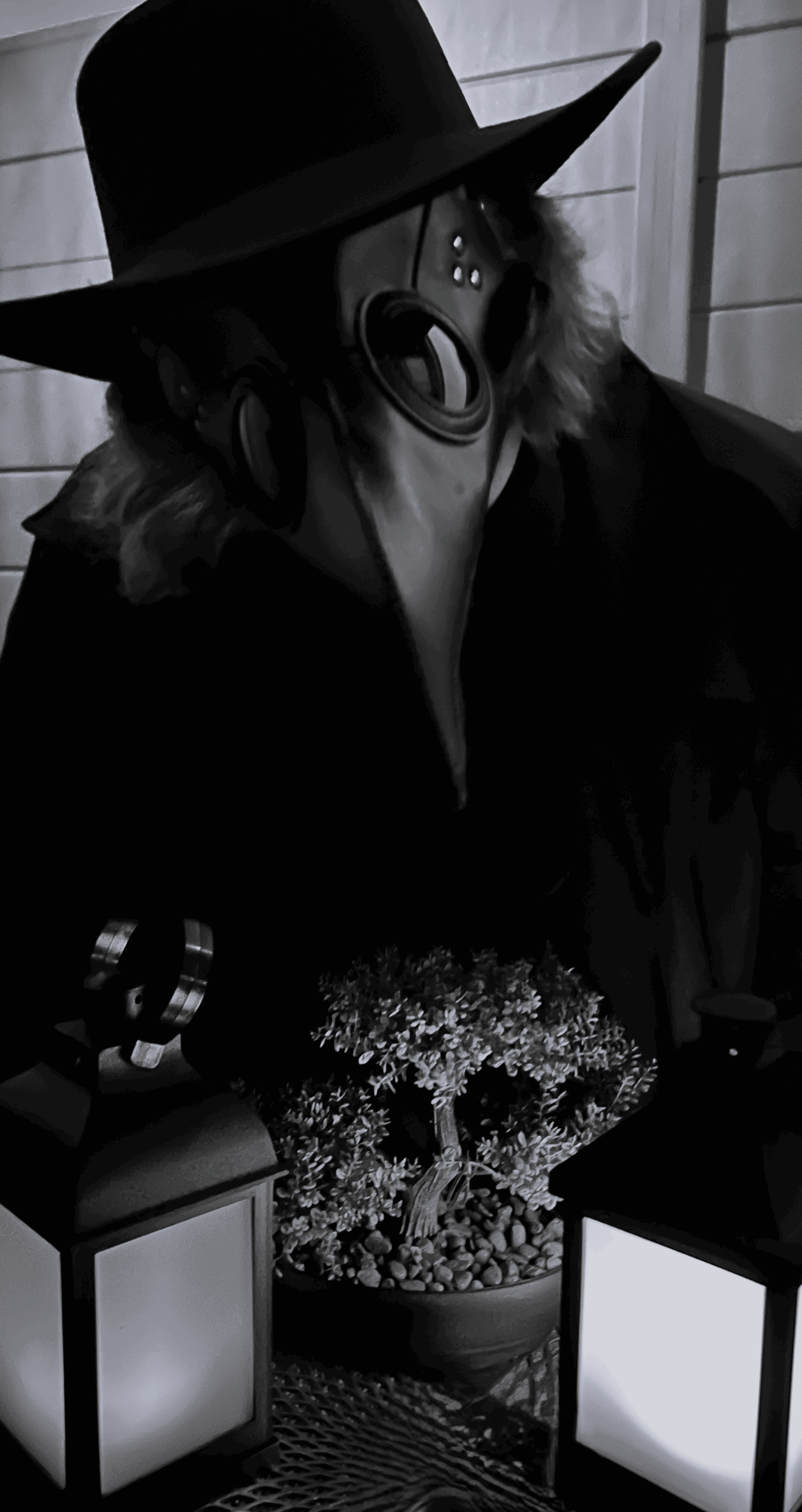 halloweenkostüm 2024, schwarzweissfoto mit schwarzem mantel, hut und pestdoktor maske